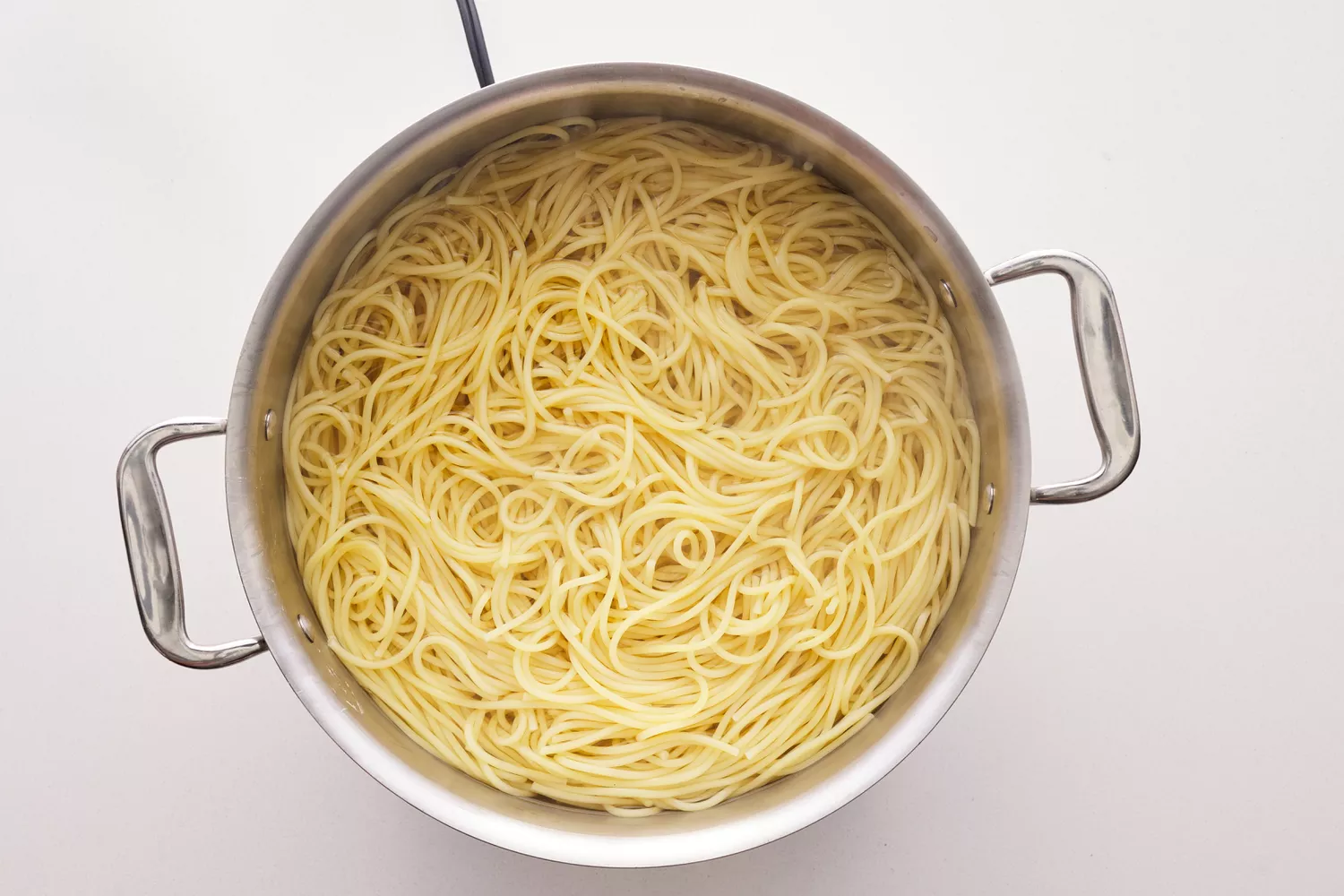 Spaghetti noodles cooking in a stock pot.