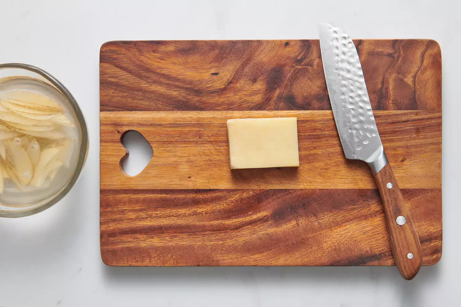 Une planche à découper avec une pile de pommes de terre tranchées en rectangle