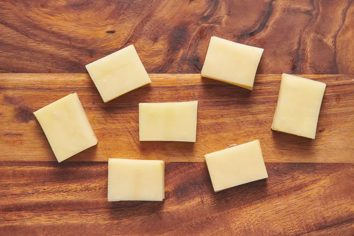 Une planche à découper avec 7 petites piles de pommes de terre tranchées superposées