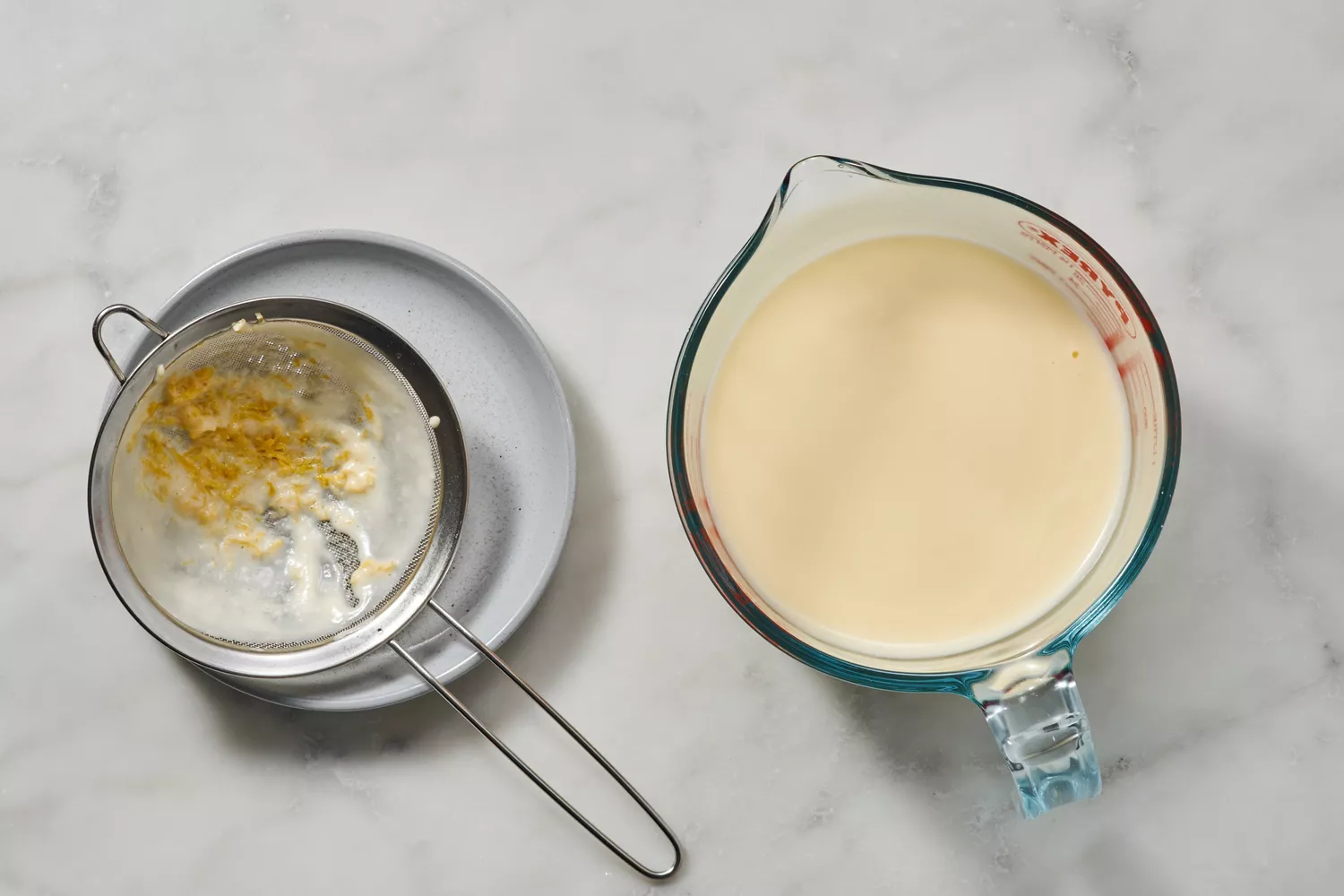 Une tasse à mesurer en verre de crème chaude, de jus de citron et de mélange de sucre