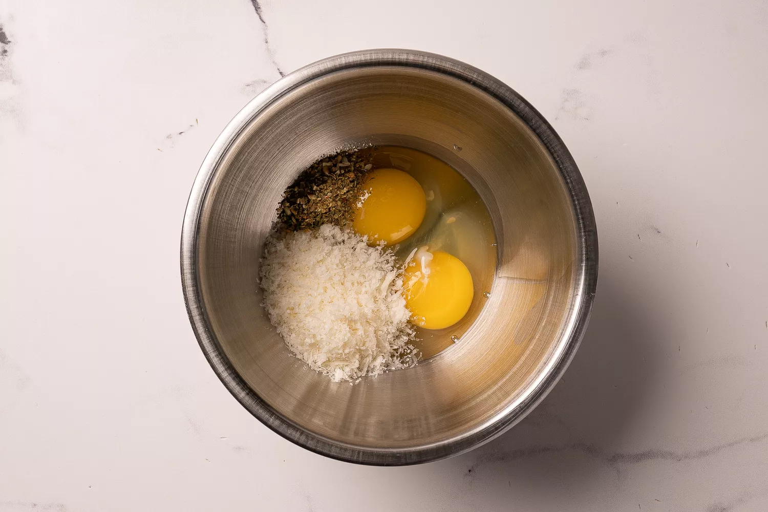Œufs, parmesan, et assaisonnement dans un bol