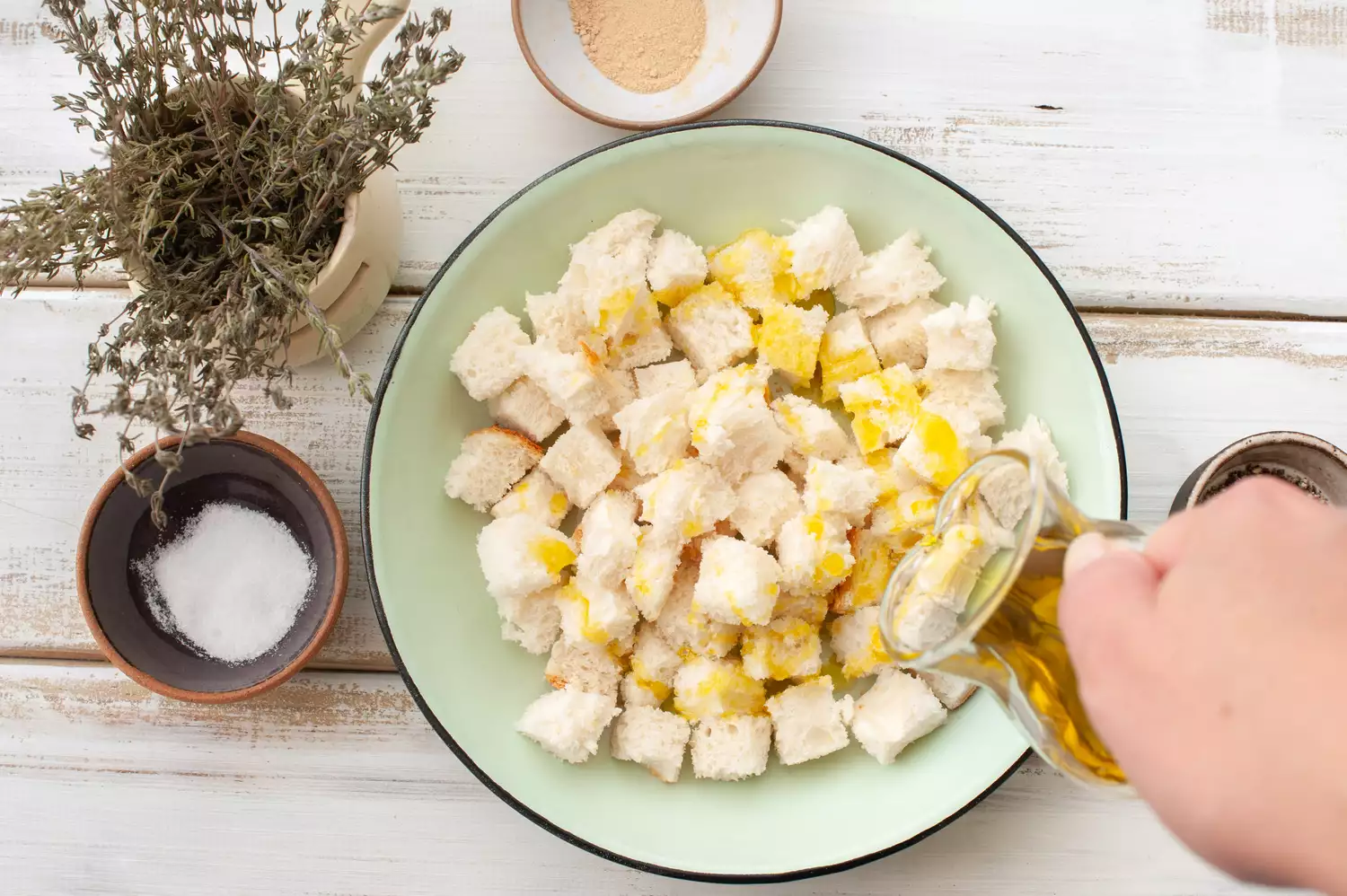 Assaisonnez les cubes de pain avec de l'huile d'olive extra vierge