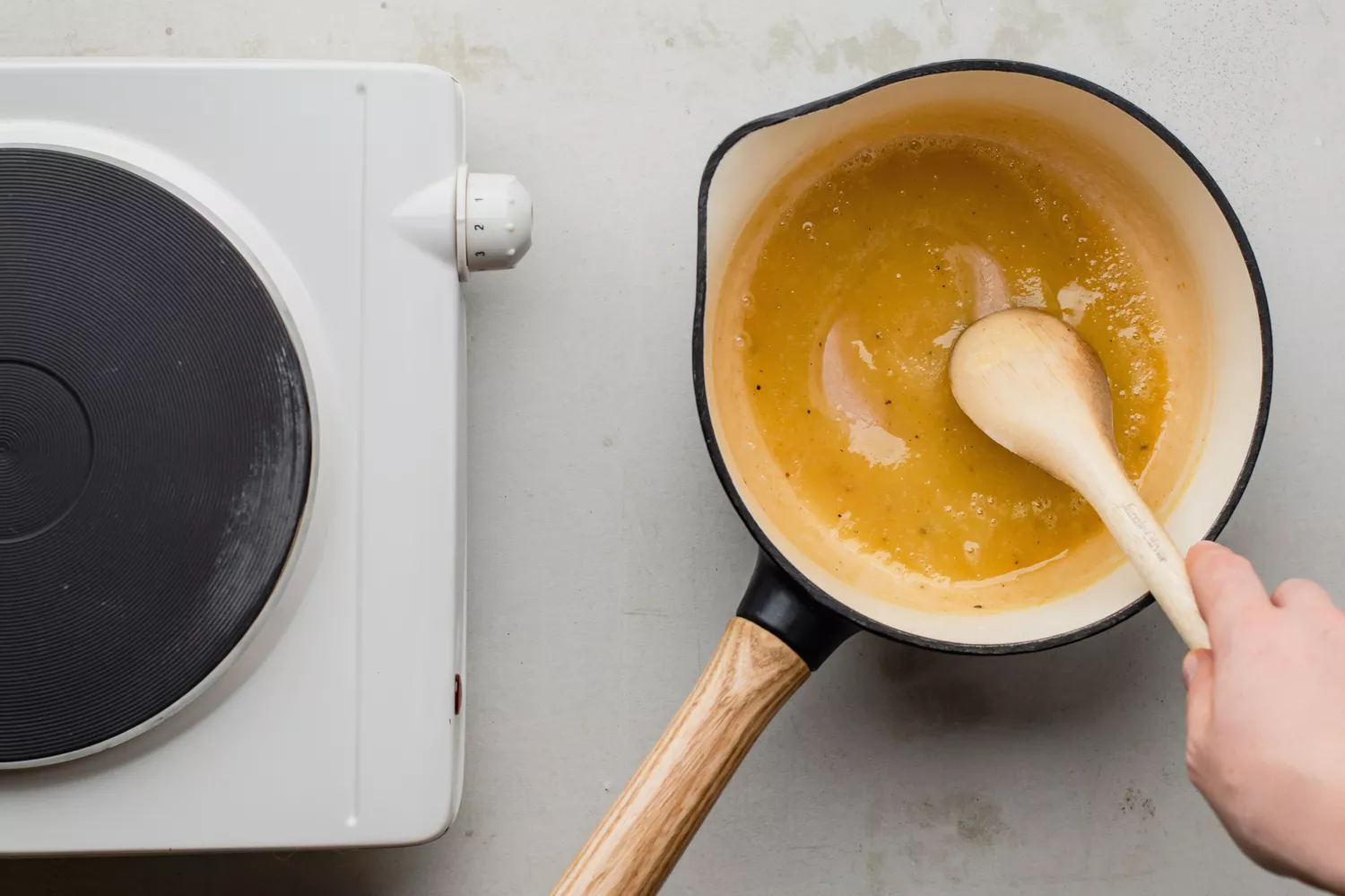 Farinha, manteiga derretida e temperos sendo misturados suavemente em uma pequena panela fora do fogo
