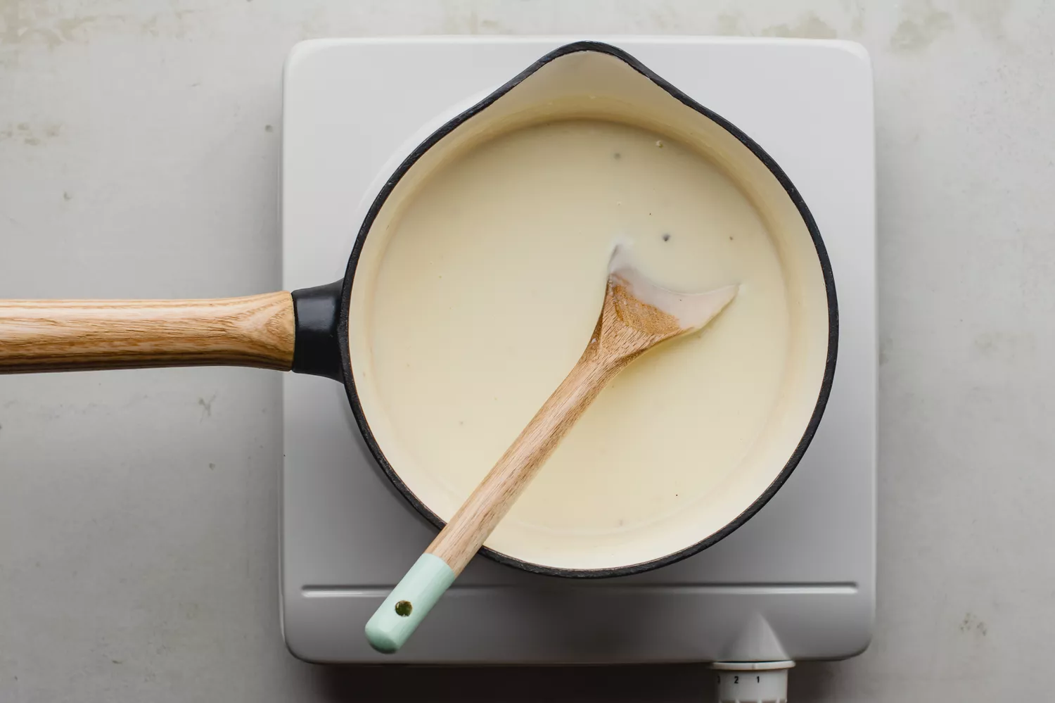 Molho espesso e suave sendo mexido com uma colher de pau