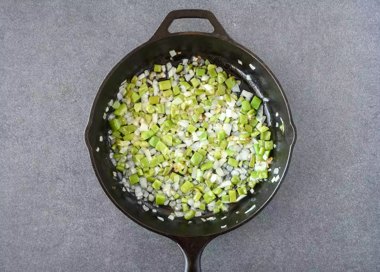 Faire revenir les oignons, poivrons et piments