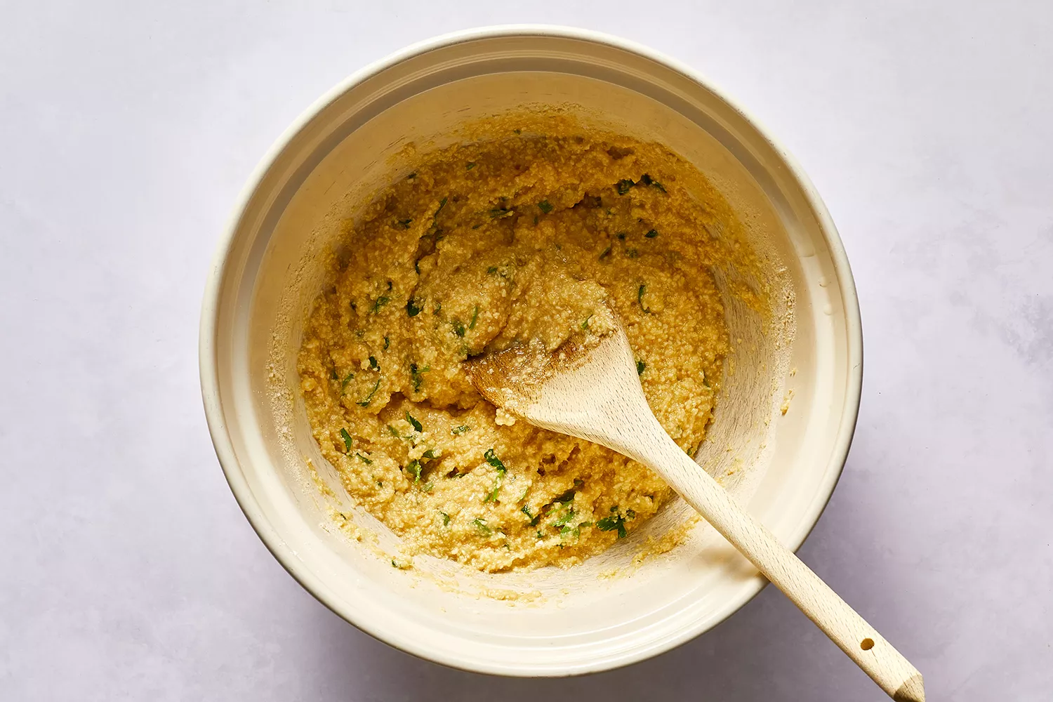 Mélange de boule de matzo dans un bol, avec une cuillère en bois