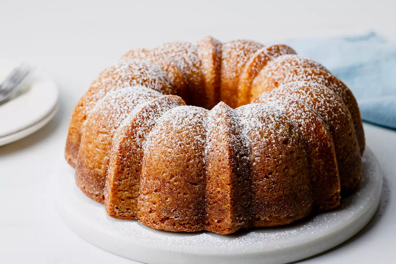 Gâteau Bundt au beurre du Kentucky retourné sur une assiette de service et saupoudré de sucre glace