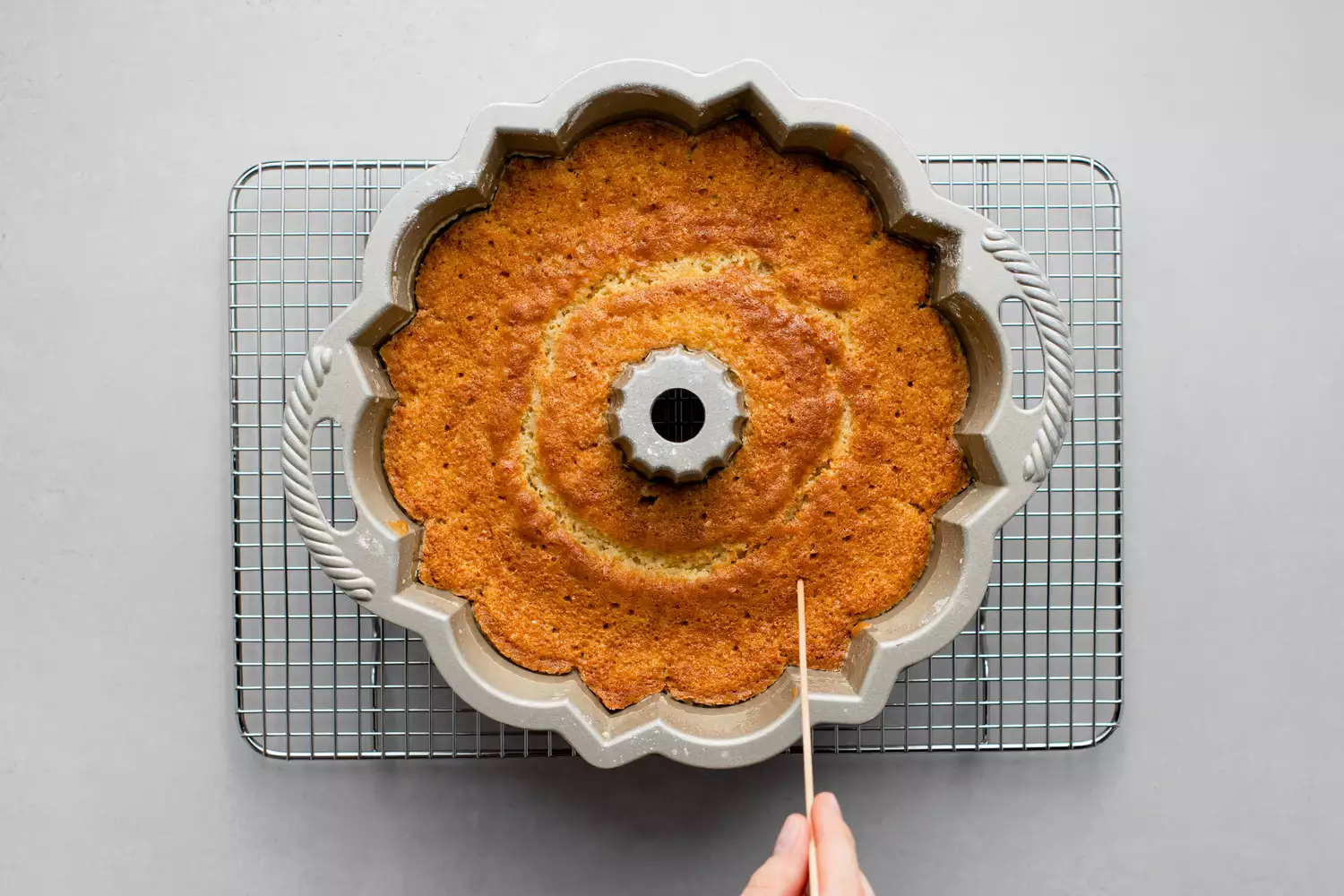 Gâteau Bundt du Kentucky dans un moule sur une grille piqué de petits trous