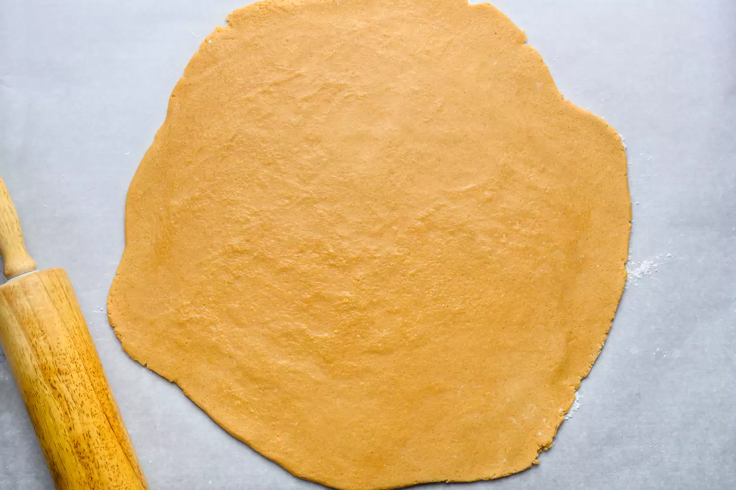 miso peanut butter cookie dough rolled out onto surface with rolling pin