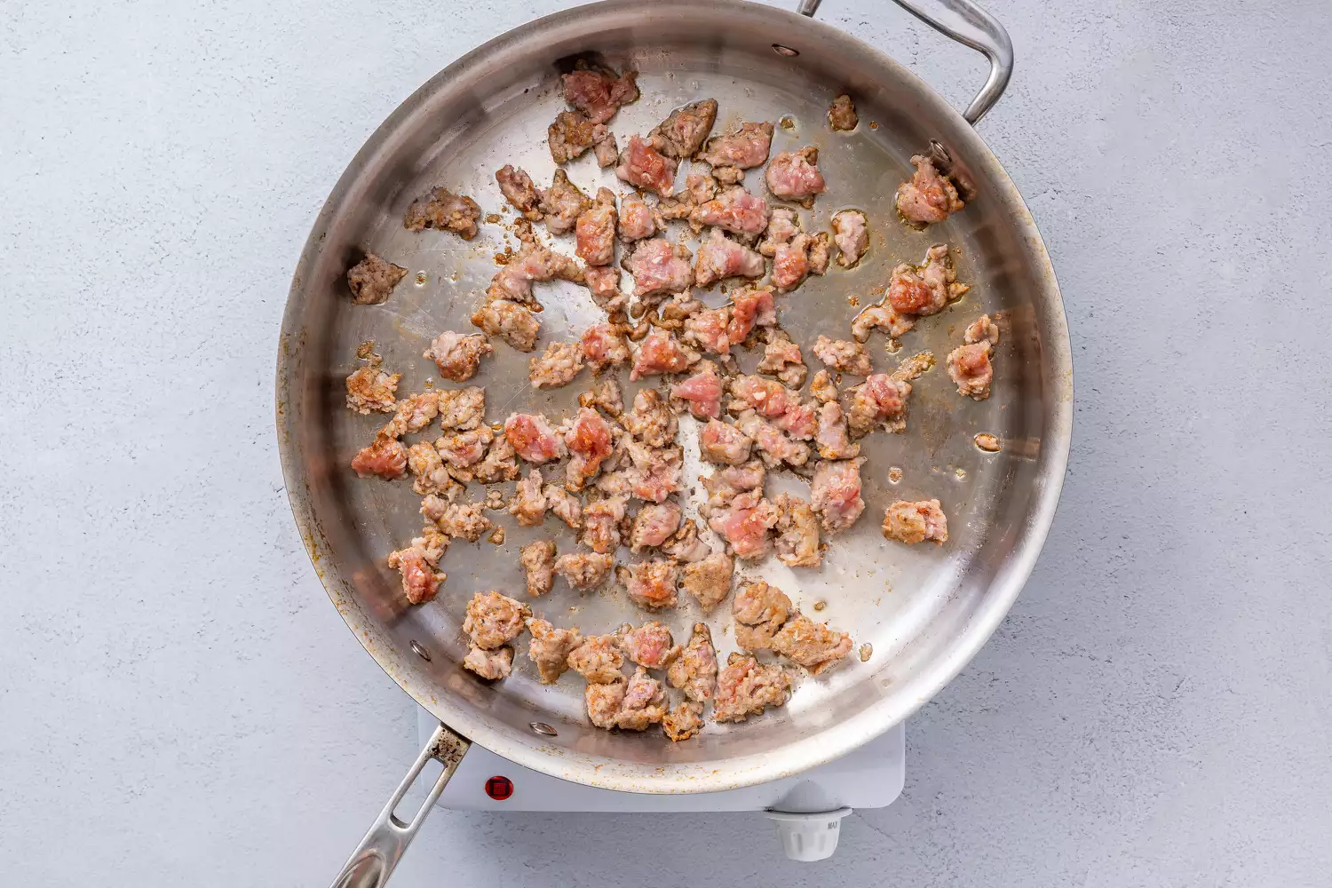 Saucisse cuisant dans une grande poêle