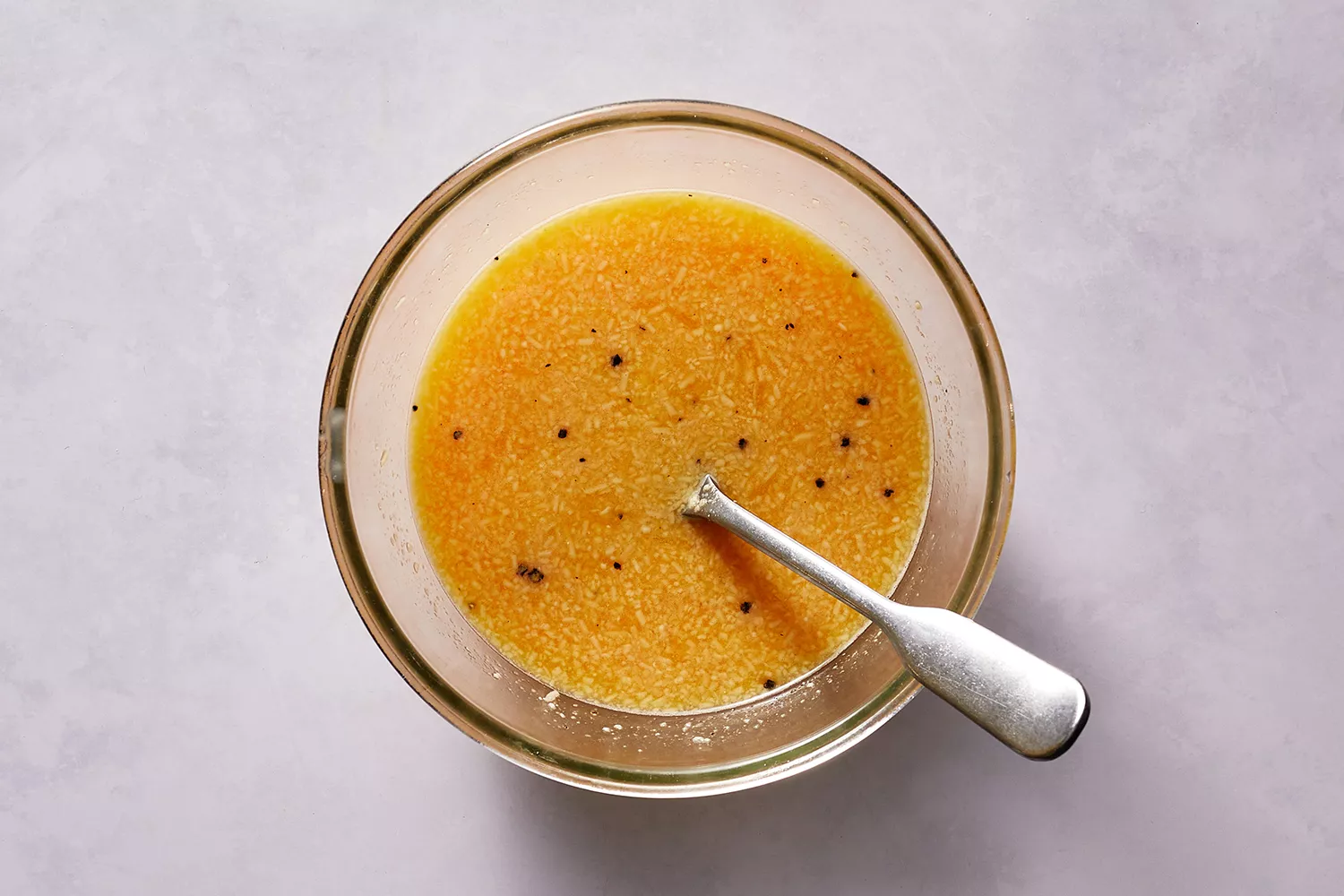 Un mélange d'œufs mélangé avec de l'eau de pâtes réservée dans un bol