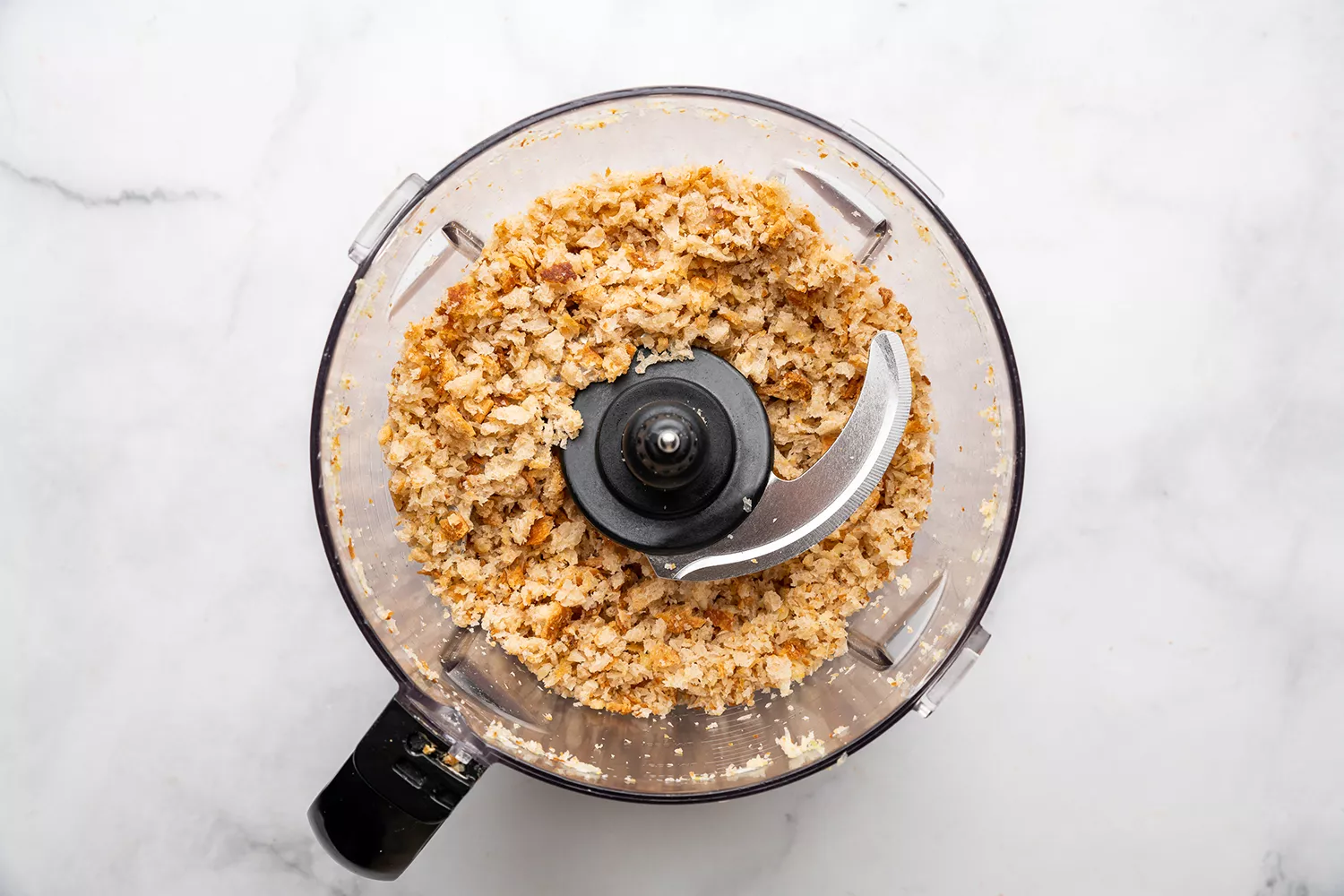 Cubes de pain, ail et sel kasher dans un robot culinaire