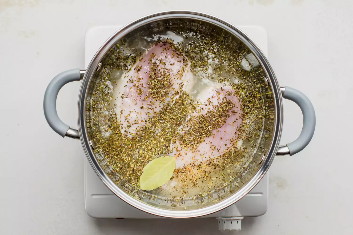 Poitrines de poulet dans un bouillon légèrement frémissant dans une casserole