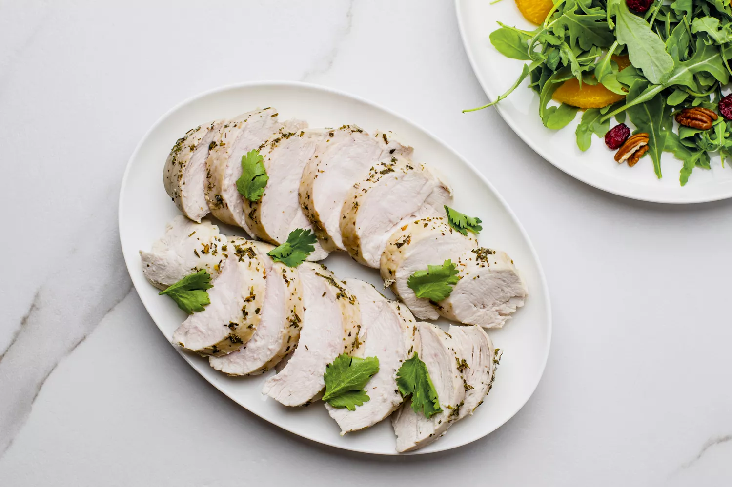 Tranches de poitrines de poulet pochées disposées sur un plateau de service