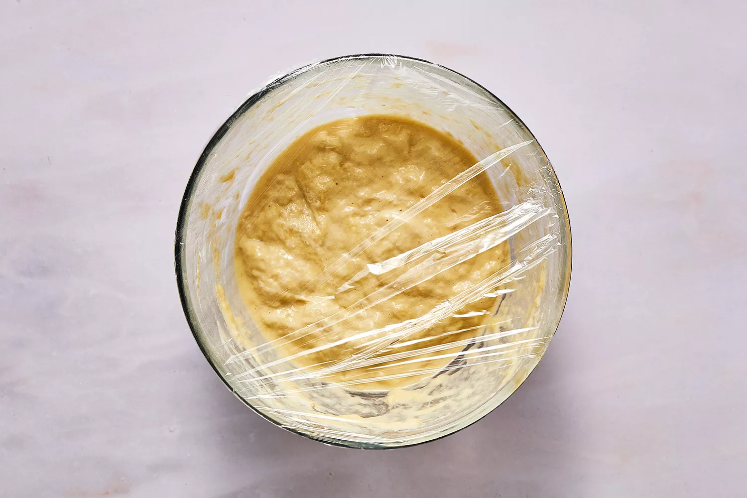 Pâte à blinis dans un bol recouvert de plastique