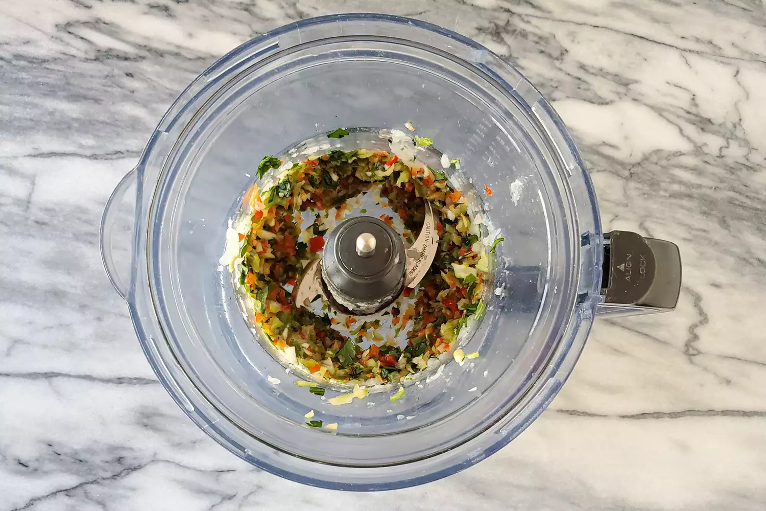 Robot culinaire avec des légumes hachés.