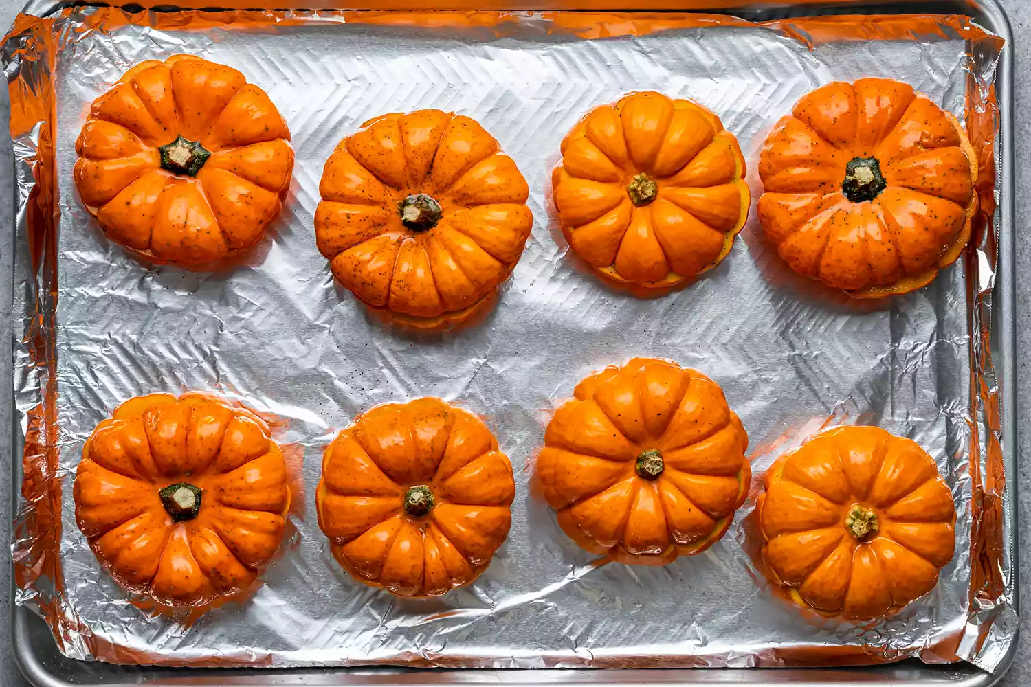 mini pumpkins on a lined baking sheet