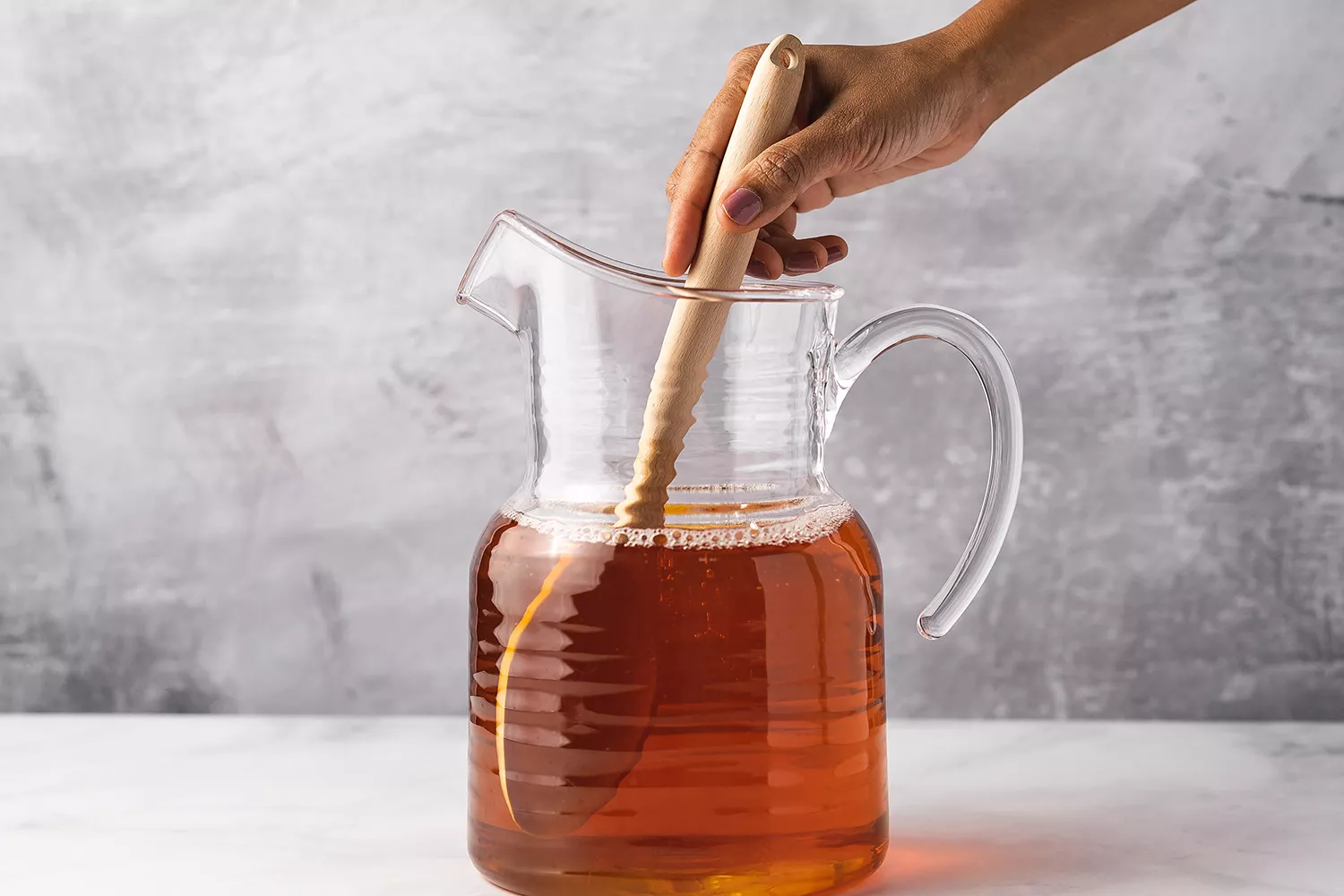 Cidre de pomme mélangé dans un pichet avec une cuillère en bois