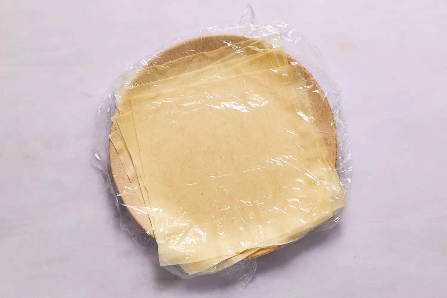 wrappers de lumpia sur une assiette couverte de plastique